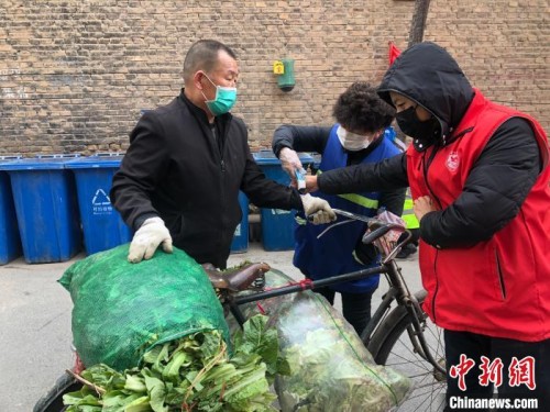 图为兰州“窄巷子”里的志愿者为邻居测体温。　徐雪 摄