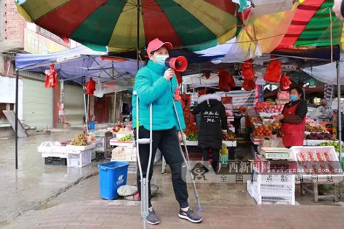 上林：社区干部覃芳平拄着拐杖为生命站岗