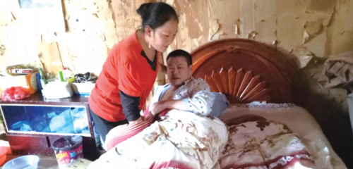 邓庆珍正在照顾车祸后下身瘫痪的丈夫