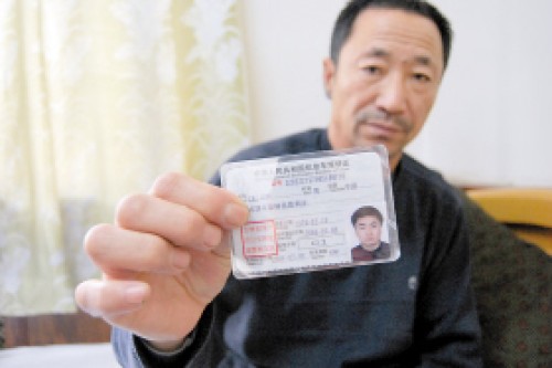 王守瑞拿着儿子王洋的驾驶证，上面有照片和出生日期 本报记者 樊亮 摄