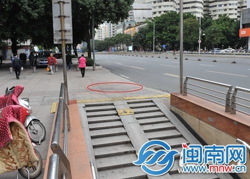 事故现场位于地下通道路口，小车冲上人行道，撞伤父女(画圈处)