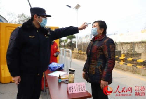 图为樊恺为居民测量体温。雨花台区城管局供图